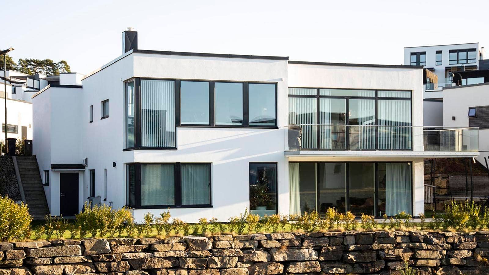 Moderne, hvitt hus med store vinduer